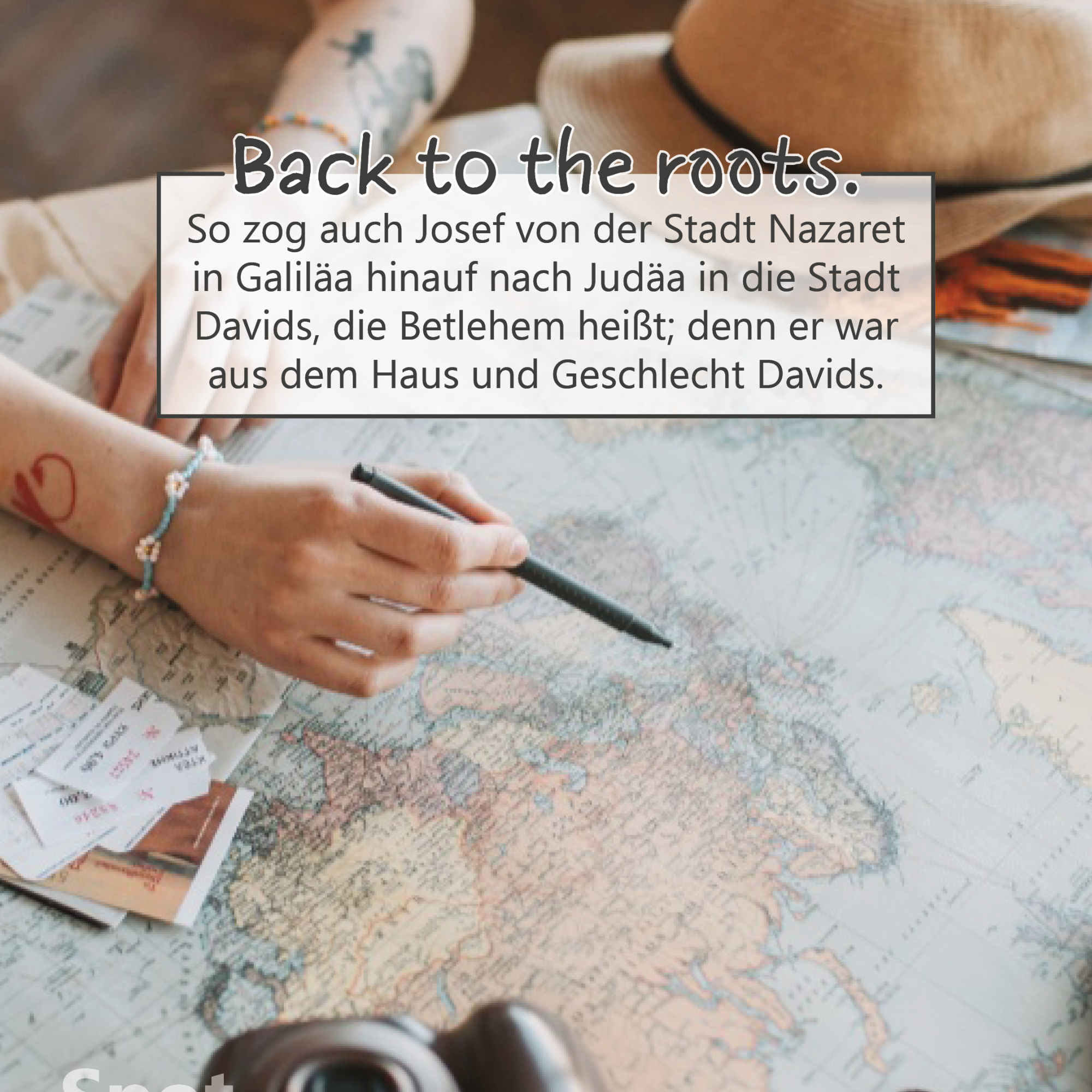 Auf einem Tisch liegt eine große, ausgebreitete Landkarte. Eine Person zeigt mit einem Stift auf eine Stelle darauf, als plane sie eine Reise. Von ihr sind nur die Unterarme sichtbar, geschmückt mit Armbändern und einer Tätowierung. Neben der Karte liegen kleine Papierzettel, eine Kamera und ein beiger Sonnenhut, was die Szene wie eine Reisevorbereitung wirken lässt. Im oberen Bildteil befindet sich ein Textkasten mit der Überschrift „Back to the roots.“ und dem Bibelvers: „So zog auch Josef von der Stadt Nazaret in Galiläa hinauf nach Judäa in die Stadt Davids, die Betlehem heißt; denn er war aus dem Haus und Geschlecht Davids.“ (Lukas 2,4).